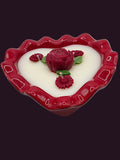 Heart-shaped candle with rose designs on a white background