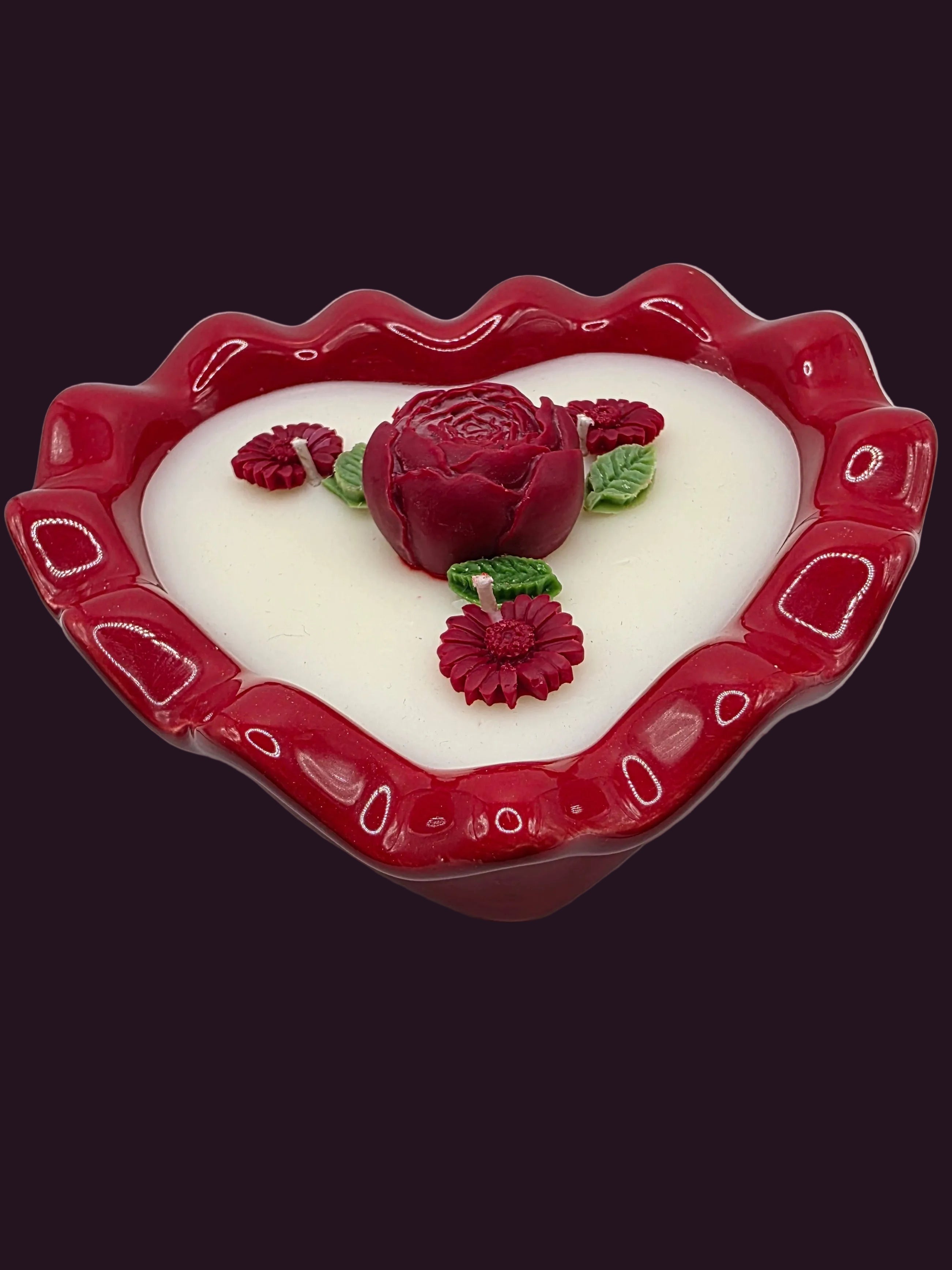 Heart-shaped candle with rose designs on a white background