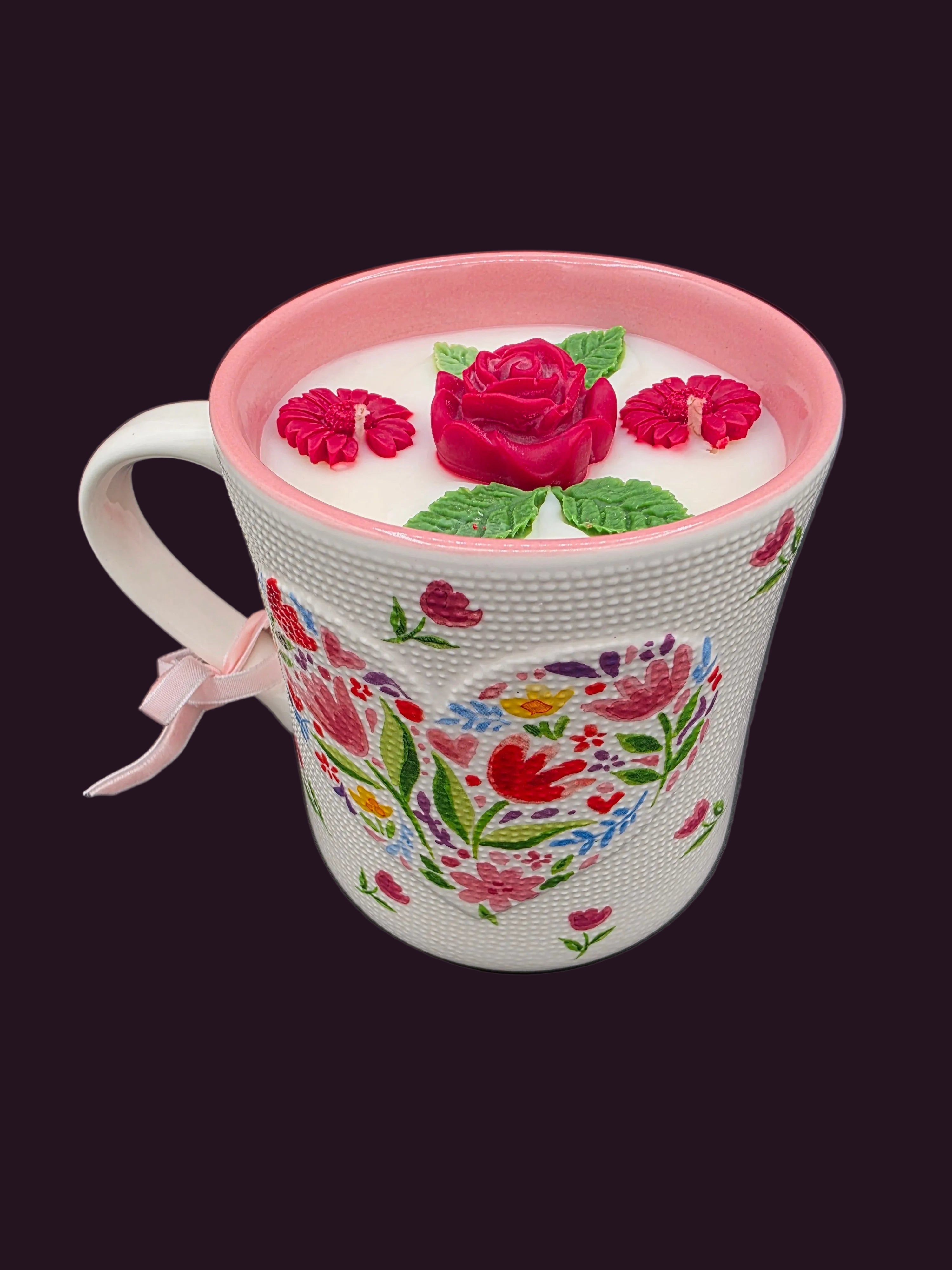 Decorative mug with floral patterns and a pink lid on a dark background