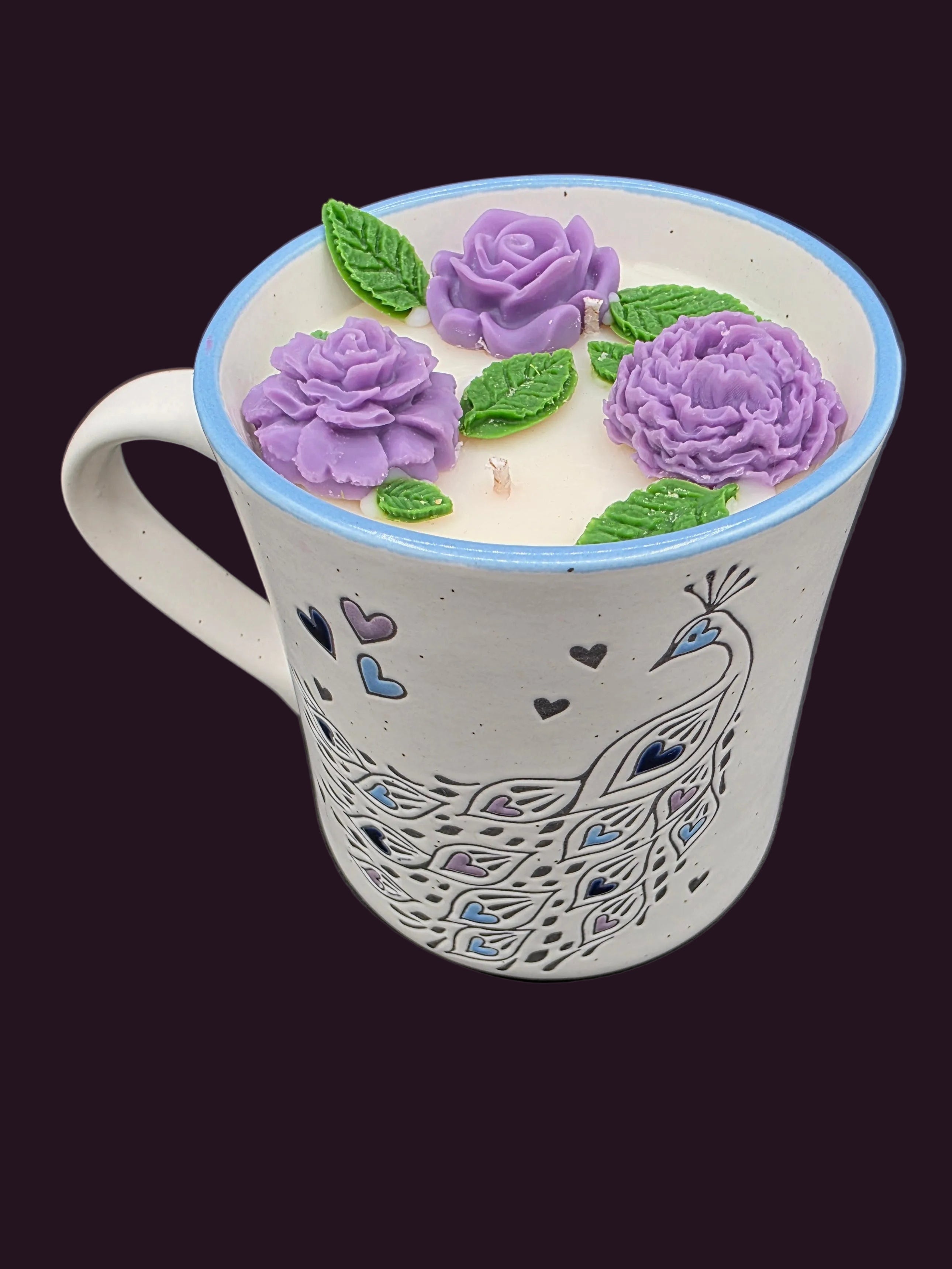 Mug with peacock design and purple floral decorations on a dark background
